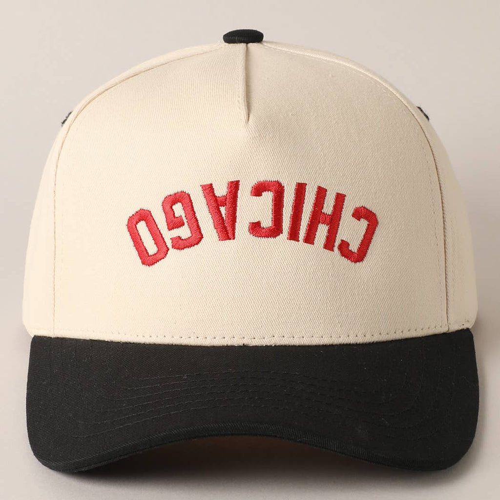 A two-toned embroidered baseball trucker hat with 'CHICAGO' embroidered in red on the front panel and a black visor.