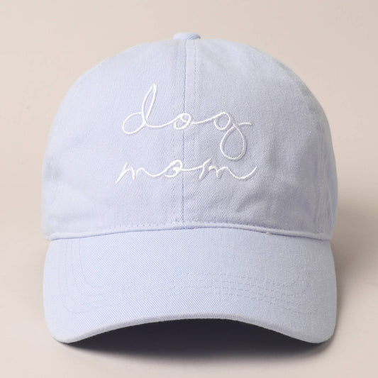 A light blue baseball cap with 'Dog Mom' text embroidered on the front.